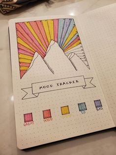 a notebook with an image of mountains and the words mood tracker on it