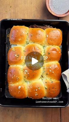 a black pan filled with bread on top of a wooden table