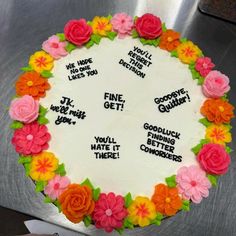 a cake decorated with flowers and sayings on the top is sitting on a table