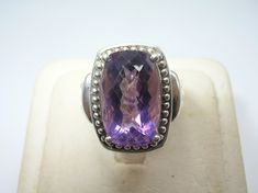 "Up for your consideration is this Vintage Sterling Silver Ring. This ring is set with a gorgeously large and faceted amethyst in the center (approx.: 9 carats); prong set. The amethyst is accented with a halo of silver beads around it. The sides of the band have deep grooves that stop halfway down; just gorgeous. Pictures best describe. Excellent condition, no damage. Ring Size is Approx.: 7.25. Measurement of Ring is Approx.: 3/4\" wide across the front. I tested this piece with acid and it is Faceted Purple Amethyst Ring For Formal Occasions, Formal Faceted Purple Amethyst Ring, Formal Faceted Amethyst Ring, Poison Ring, Mother Of Pearl Earrings, Vintage Sterling Silver Rings, Amethyst Gem, Purple Band, Amethyst Ring