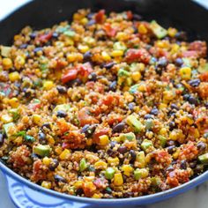 a skillet filled with beans, corn and other vegetables on top of a table