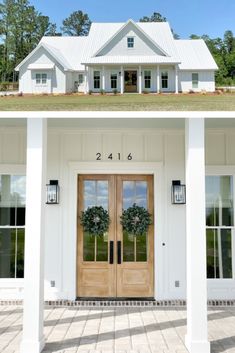 the front and side doors of a white house with two wreaths on each door