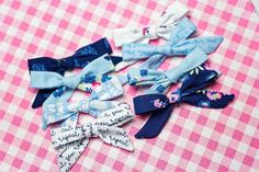 several different types of hair bows on a pink and white checkered tablecloth