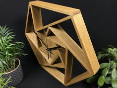 a wooden clock sitting next to a potted plant