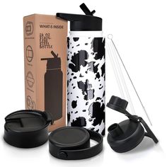 the black and white bottle is next to two cups, an open box and a straw