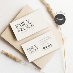 two business cards sitting on top of an envelope next to some dried plants and flowers