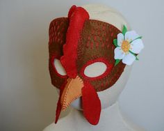 a white mannequin head wearing a red mask with flowers on it's side