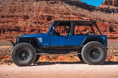 a blue jeep is parked in the desert