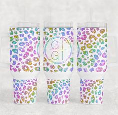 three colorful leopard print tumblers with monogrammed letters on the bottom and sides