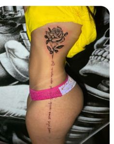 a woman with a rose tattoo on her lower back