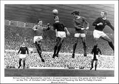 an old black and white photo of soccer players jumping in the air to head the ball