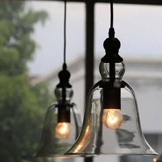 three glass bell lights hanging from a window