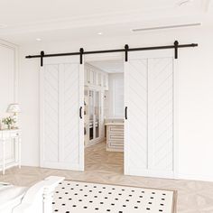 an open door leading to a bedroom with white walls and black hardware on the sliding doors