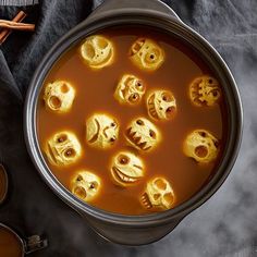 a pot filled with soup and lots of skulls in it