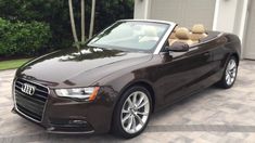 a brown car parked in front of a garage