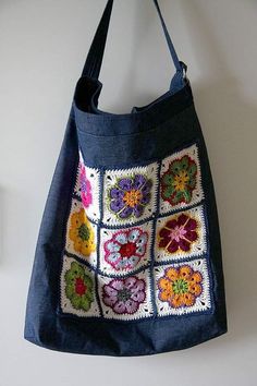 a handbag hanging on the wall with crocheted squares and flowers in it