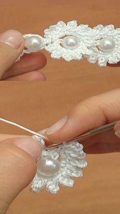 someone is knitting something with white yarn and pearls on it's end, while another hand holds the string