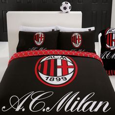 a black and red comforter with soccer balls on the bed in front of it