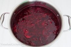 a pot filled with red liquid sitting on top of a stove