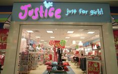 a store front with the words justice just for girls on it's display window