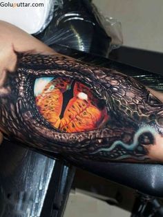 an arm with a dragon eye tattoo on it