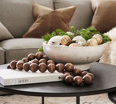 a white bowl filled with balls sitting on top of a table next to a book