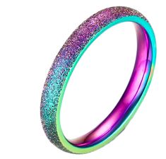 a purple and green ring with glitter in the middle on a white background, close up