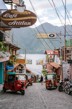 the street is lined with shops and parked motorcycles in front of it, along with mountains