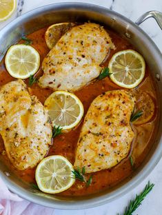 chicken with lemons and herbs in a pan