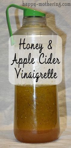 a jar filled with honey and apple cider vinaigrette sitting on top of a table