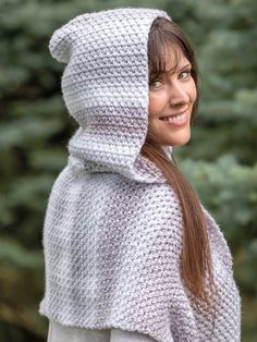 a woman wearing a white knitted hooded ponchy