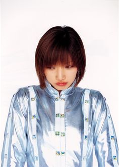 a woman with short hair wearing a silver shirt