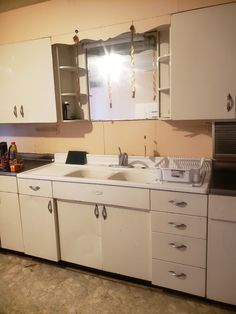 an old kitchen with white cabinets and appliances