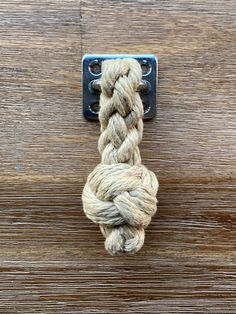 a rope is attached to a metal hook on a wooden surface with wood planks