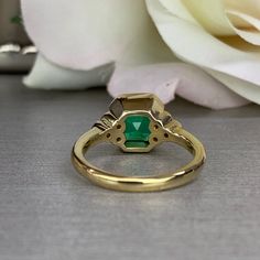 "The ring pictured is lab created emerald with moissanite accents. Also shown in 14k white gold instagram: https://www.instagram.com/p/BvKUII-lfxA/ -Approximate total carat weight: approx. 2.30ctw diamond equivalent -Center Stone Size: 8x8mm - approx. 2.20ct diamond equivalent -Center Stone Shape: asscher -Gem Type: lab created emerald -Stone Clarity: VS2 -Stone Color: Green -Moh's Scale: 8.5 hardness -Side Stones Size: 6 round - approx. 0.12ctw. diamond equivalent -Gem Type: moissanite -Metal T Bezel Set Baguette Cut Emerald Ring, Emerald Baguette Cut Ring With Bezel Setting, Baguette Cut Emerald Ring With Bezel Setting, Baguette Cut Bezel Set Emerald Ring, Heirloom Green Diamond Ring With Bezel Setting, Heirloom Green Emerald Ring With Bezel Setting, Octagon Emerald Ring With Halo Setting For Anniversary, Art Deco Gia Certified Emerald Ring As Gift, Heirloom Emerald Ring With Accent Stones And Round Cut