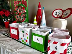 several bags are lined up on a table with numbers and christmas decorations in the background