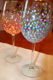 two wine glasses sitting on top of a table covered in confetti and glitter