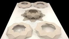 paper sculptures are arranged on a table with circles and pentagons in the middle,