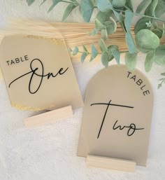 two place cards with the word table one written on them next to some leaves and twigs