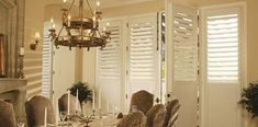 a dining room table set with place settings for six and a chandelier hanging from the ceiling