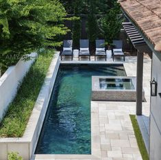 an outdoor swimming pool surrounded by greenery