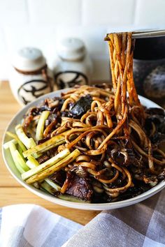 a bowl filled with noodles and vegetables on top of a table