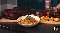 a person is preparing food on a cutting board with meat and sauces in the background