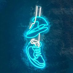 a neon sign that is lit up in the shape of a shoe on top of grass