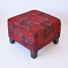 a red and blue ottoman sitting on top of a white floor