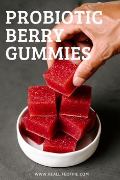 someone is picking up some red jellies out of a white bowl with the words probiotic berry jellies on it