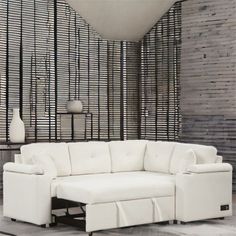 a white sectional sofa sitting on top of a tiled floor next to a vase and lamp