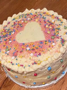 a cake with sprinkles on it sitting on top of a wooden table