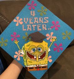 a person wearing a blue graduation cap with an image of spongebob on it