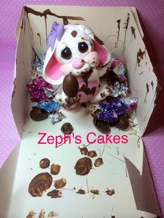 a small toy rabbit sitting inside of a box filled with chocolate candies and candy